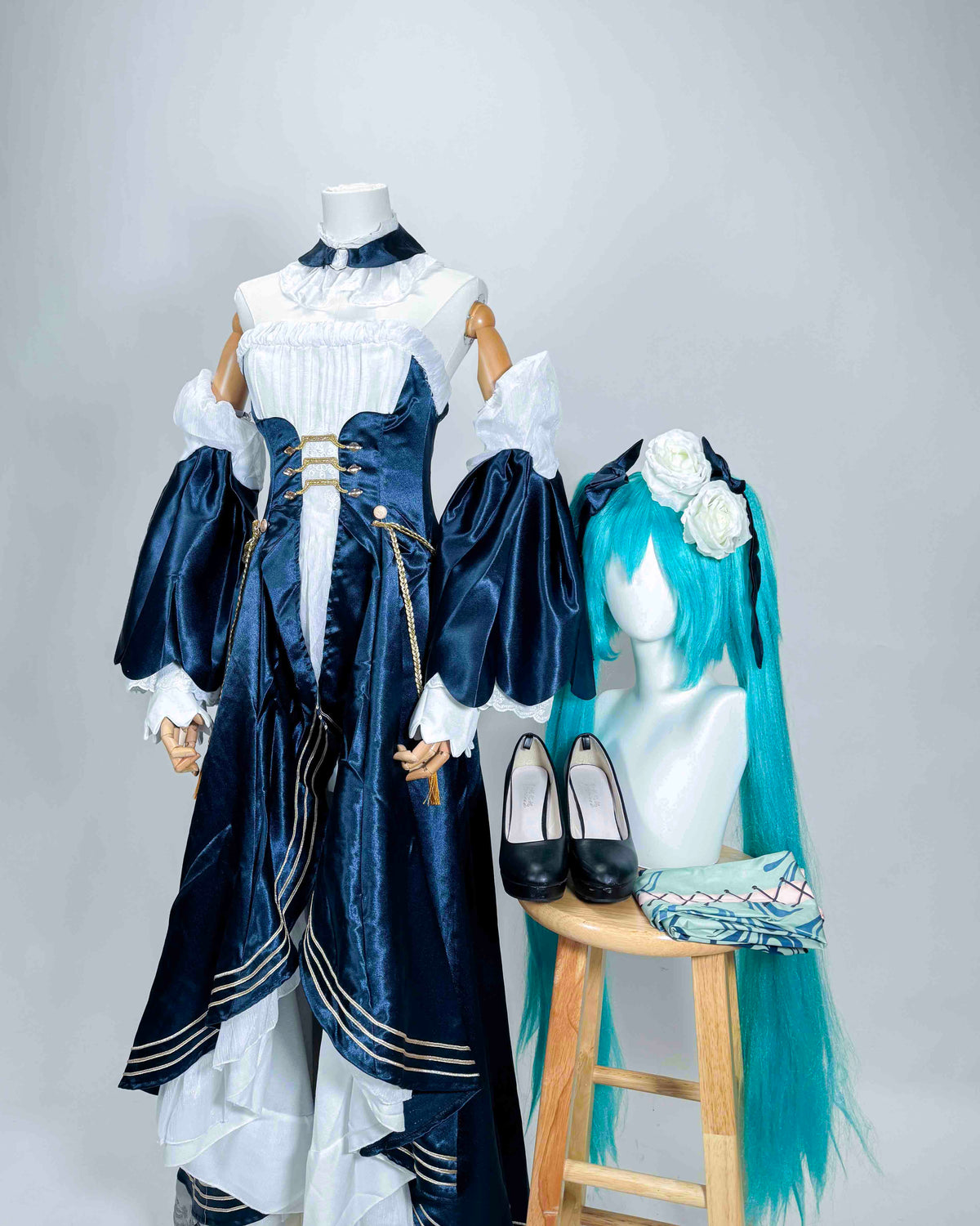 Full-length view of the Hatsune Miku navy and white cosplay dress displayed with a turquoise wig and matching accessories