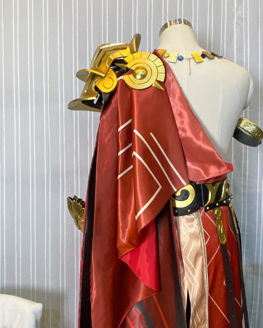 Angled upper-body view of the Mydei costume showing gold shoulder armor and the red patterned drape